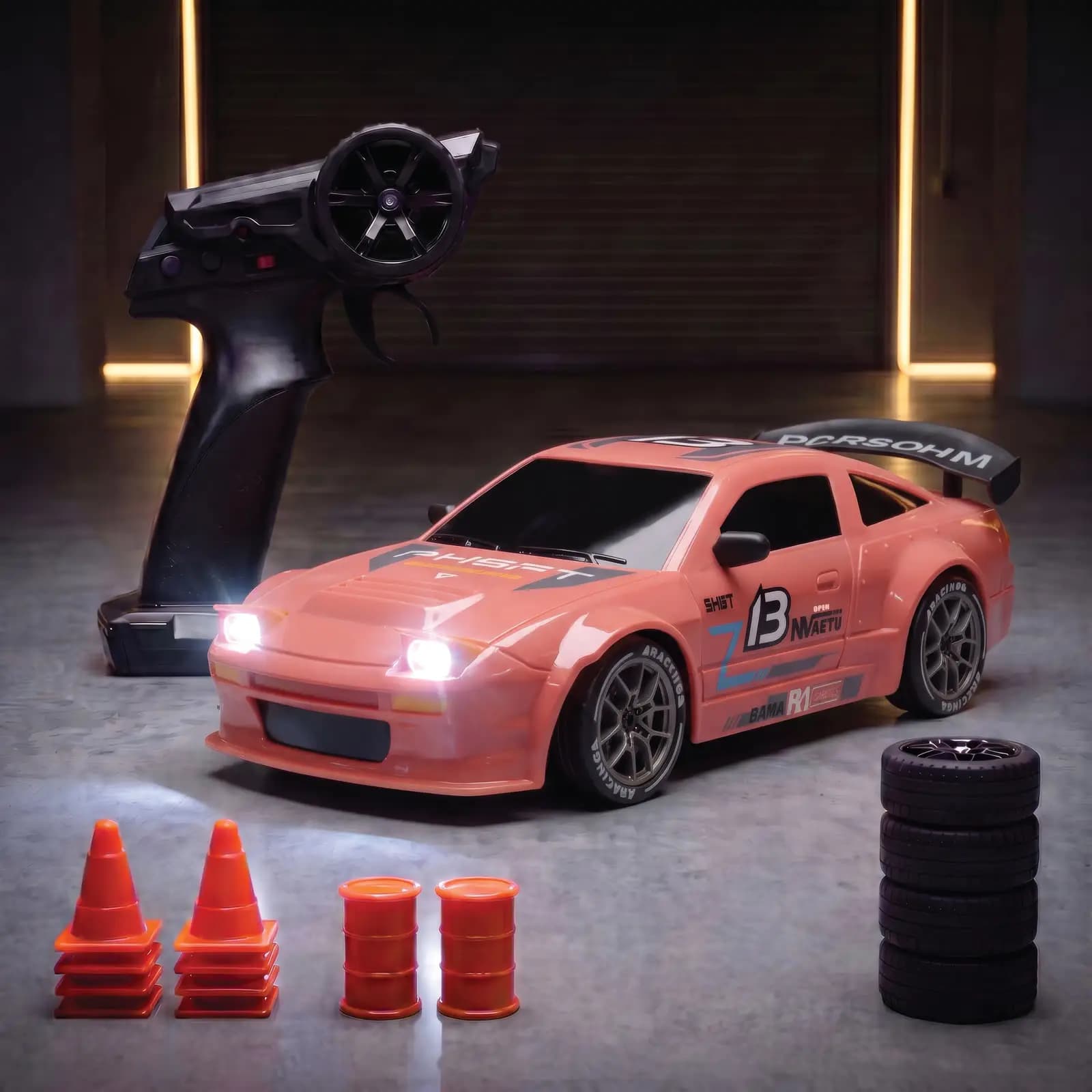 The pink race coupe with a rear wing, lights on, next to the remote, four spare wheels, eight cones and two barrels